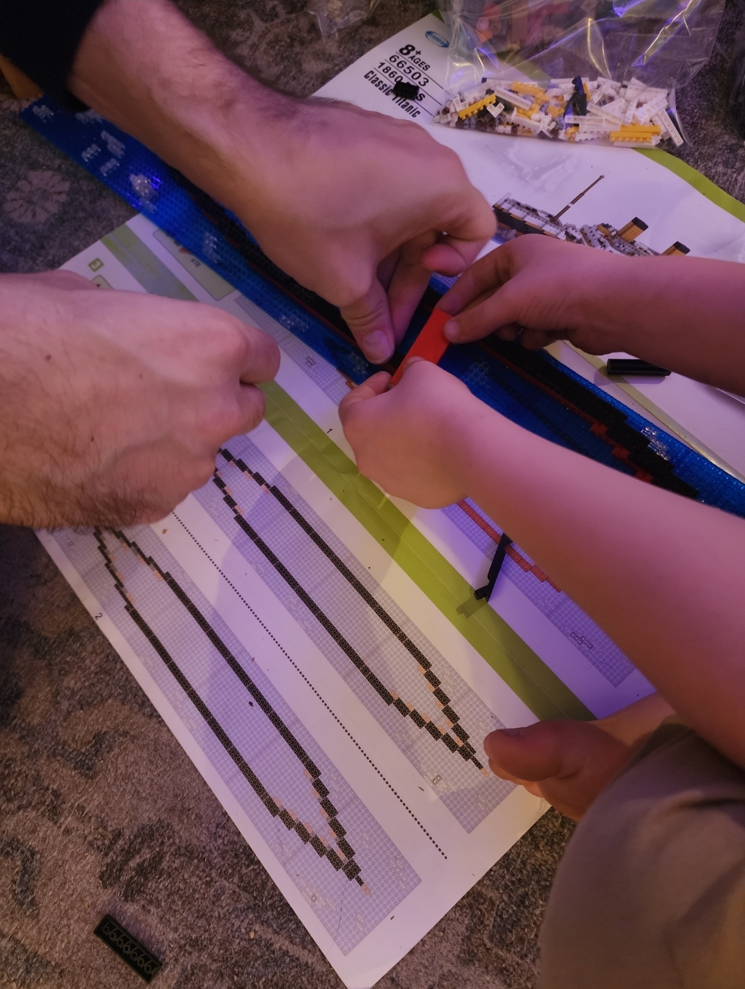 adult and child putting lego titanic together